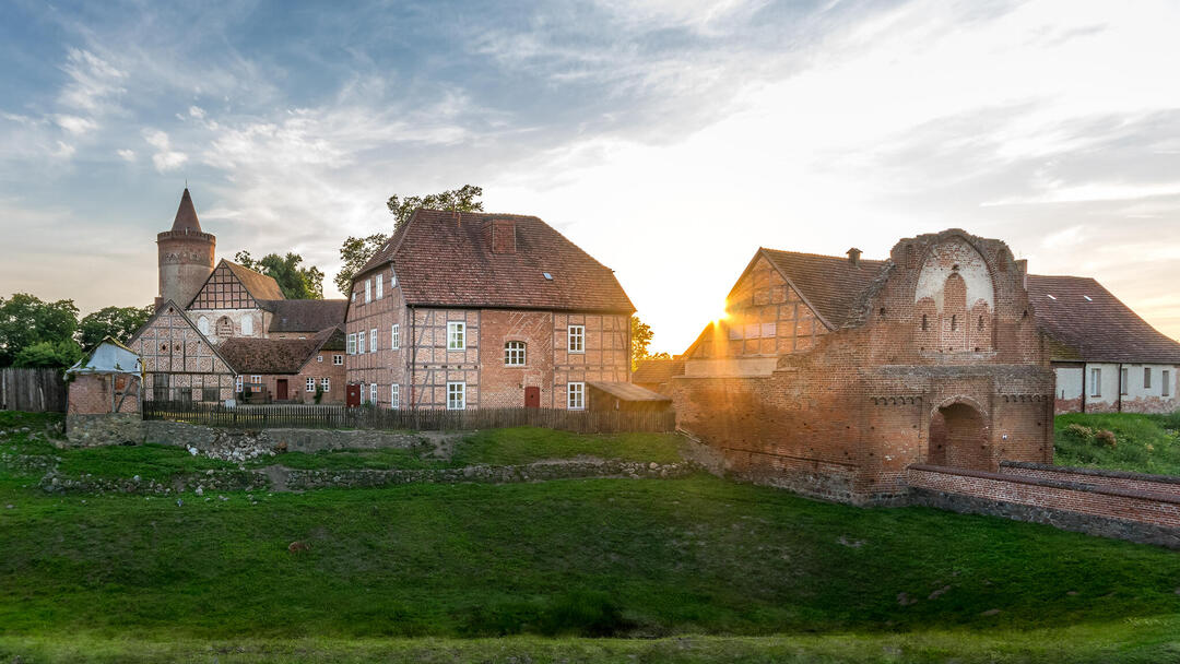 Die Burg Stargard im Sonnenuntergang unter einem leicht bewölkten Himmel.