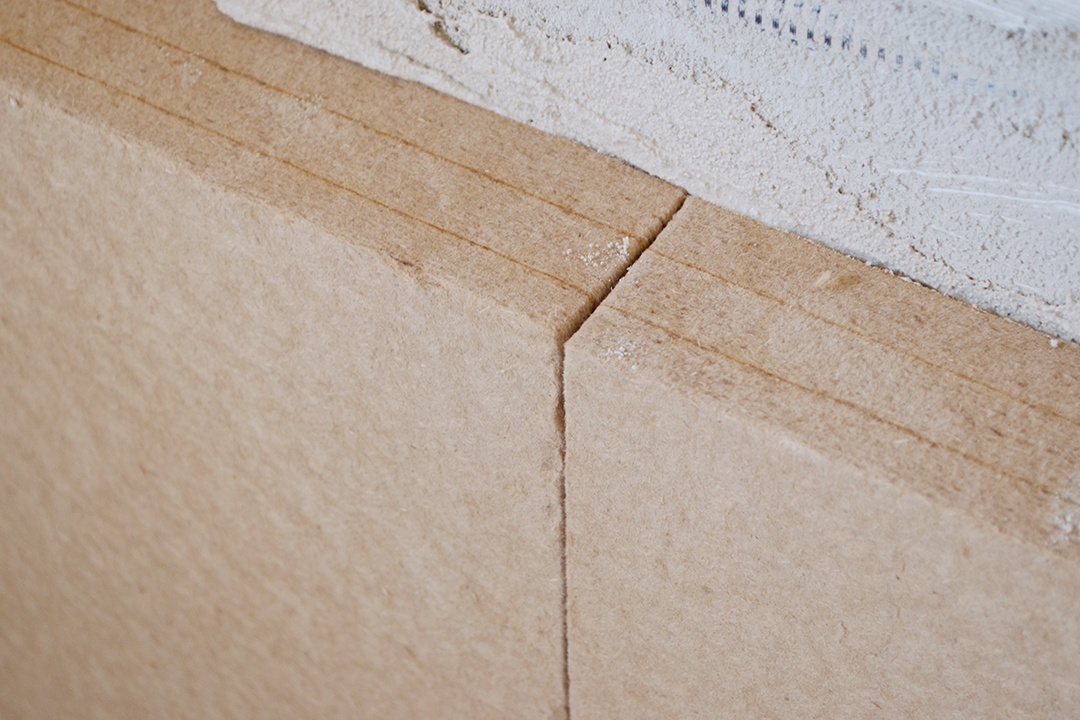 Detailaufnahme von zwei aneinander angrenzenden STEICO-Platten, die an einer Wand angebracht sind.