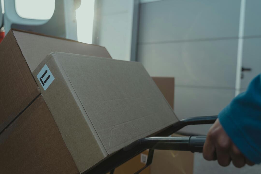 Kartons werden auf einer Schubkarre gezogen.