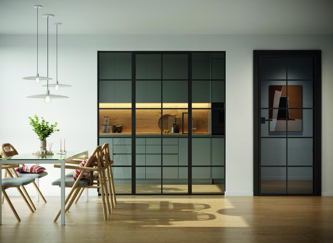 Ein modernes Wohnzimmer mit Esstisch und Blick auf die ästhetischen Steel Line Türen, die in die Küche führen.
